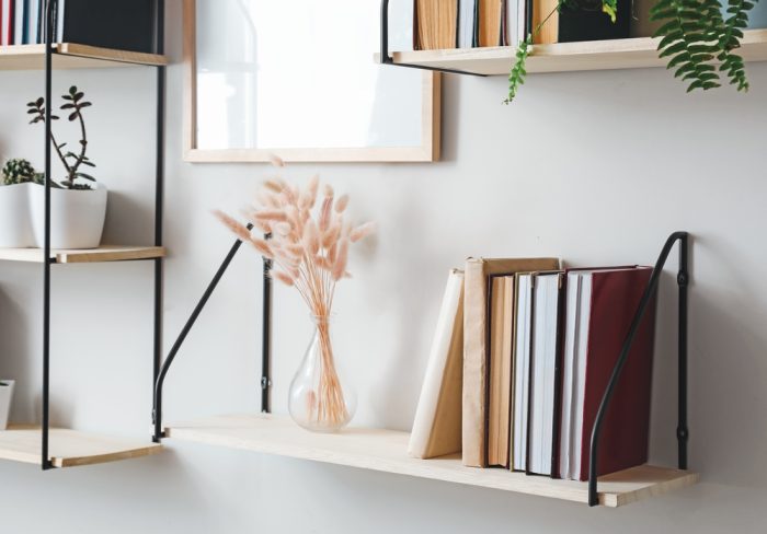 Floating bookshelves with books and plants.